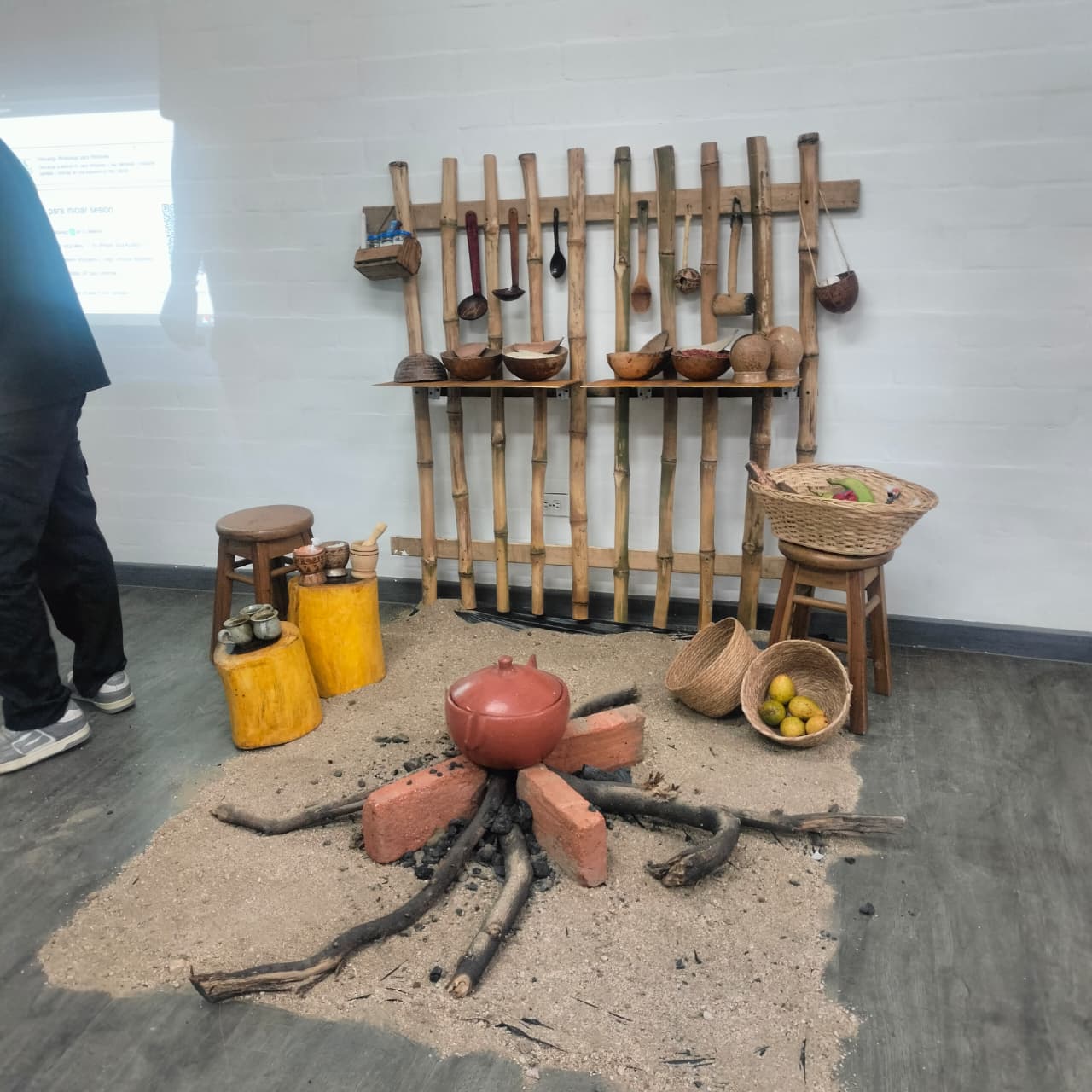 Montaje expositivo con utensilios y elementos culinarios, presentado por estudiantes que explican tradiciones gastronómicas locales.