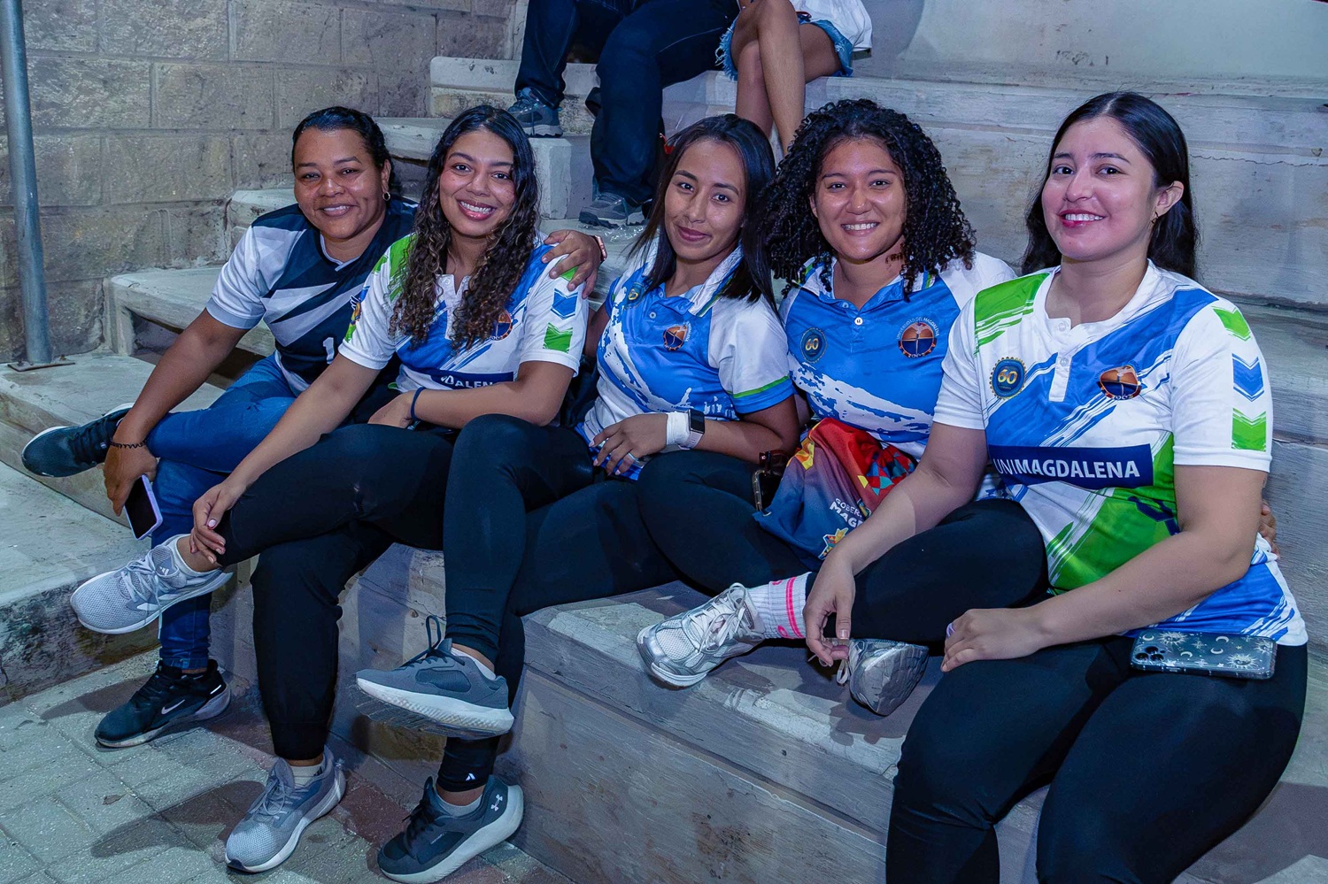 Egresados se saludan antes de iniciar el partido inaugural en las competencias de fútbol masculino.