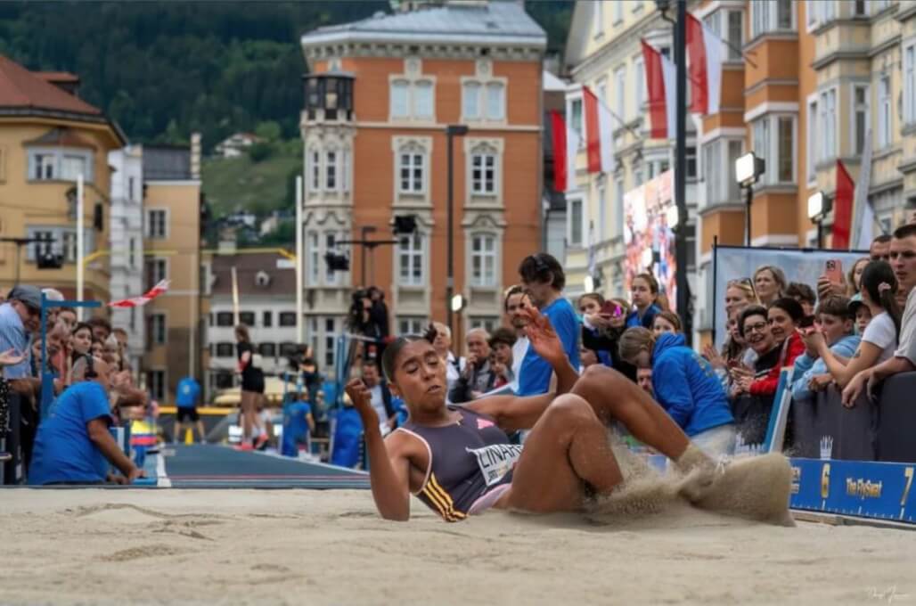La atleta Natalia Linares González, estudiante de sexto semestre del Programa Profesional en  Deporte, es observada por el público austriaco en el momento en que hace su salto.