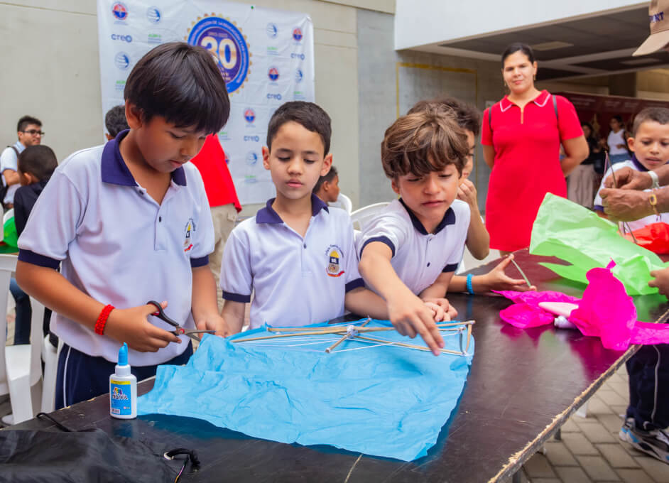 Niños asistentes en la elaboración de sus cometas.